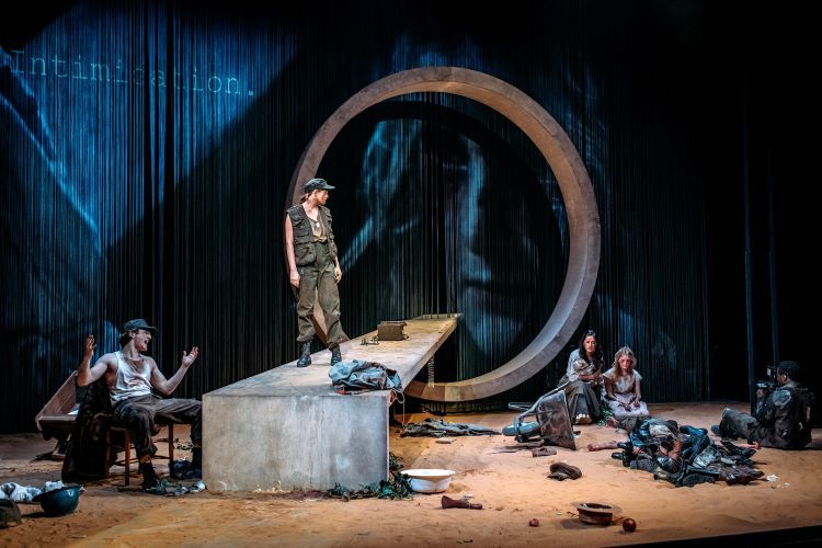Actors on the set of The Wheel, with a large concrete circle and walkway in the centre of the stage
